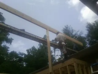 Carpenter setting a ridge beam over a new addition frame — Ice Dam Removal by Roofing Brothers in Gorham