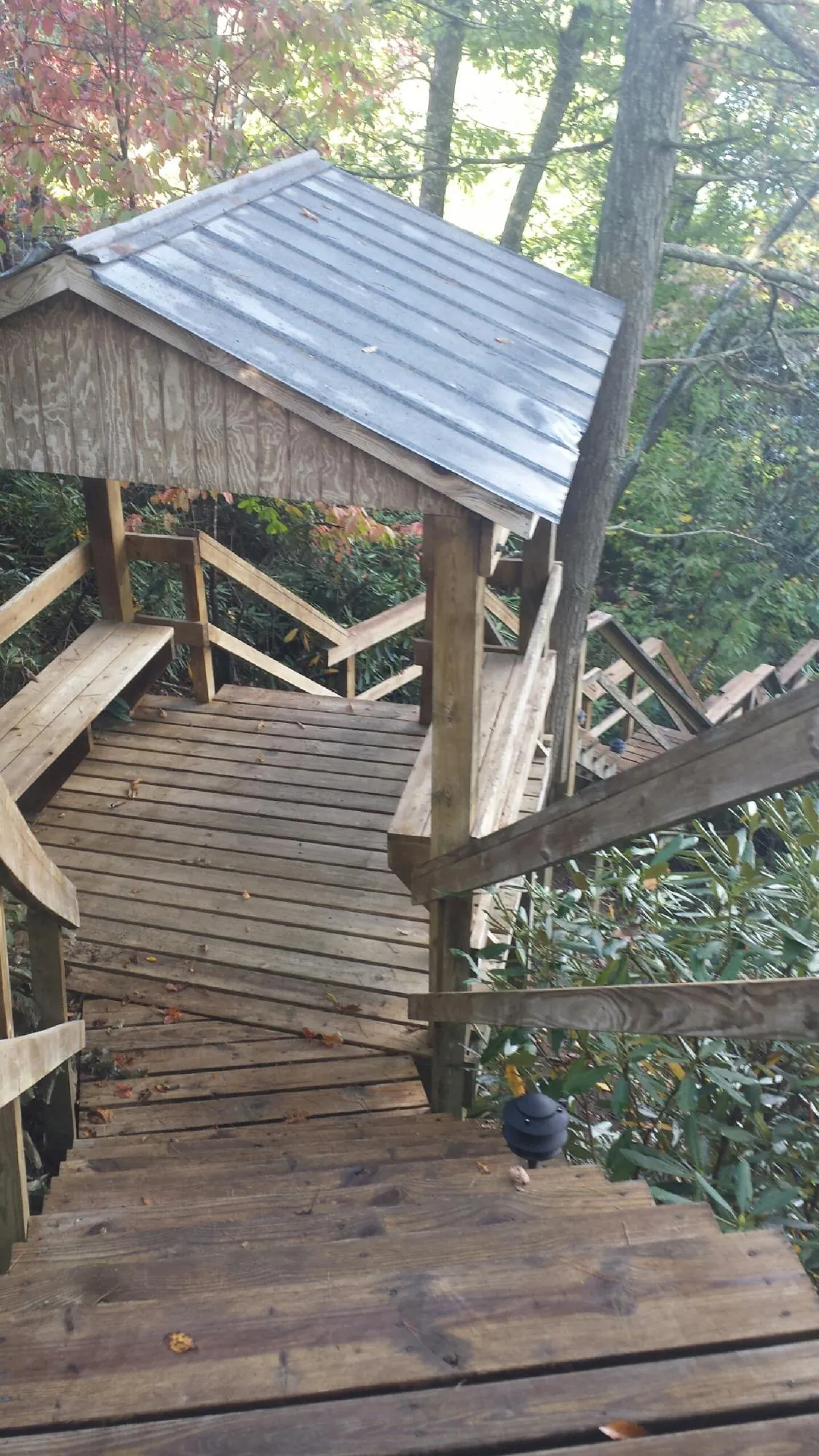 Metal roofed shelter over wooden steps on a wooded walkway — Skylight Repair & Installation work by our crew in Gorham